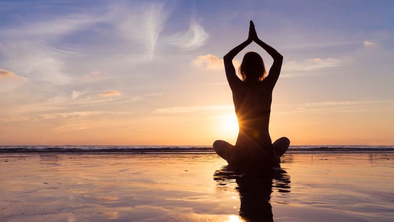 Woman in yoga post on the beach